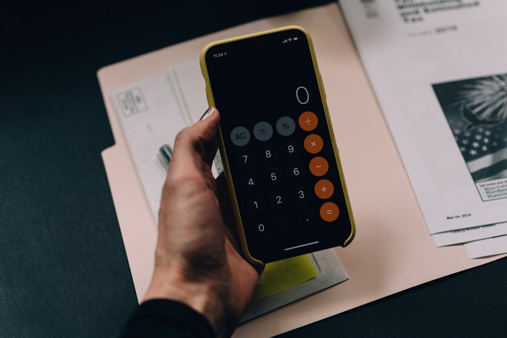 A person reviewing a financial document with a calculator at a desk